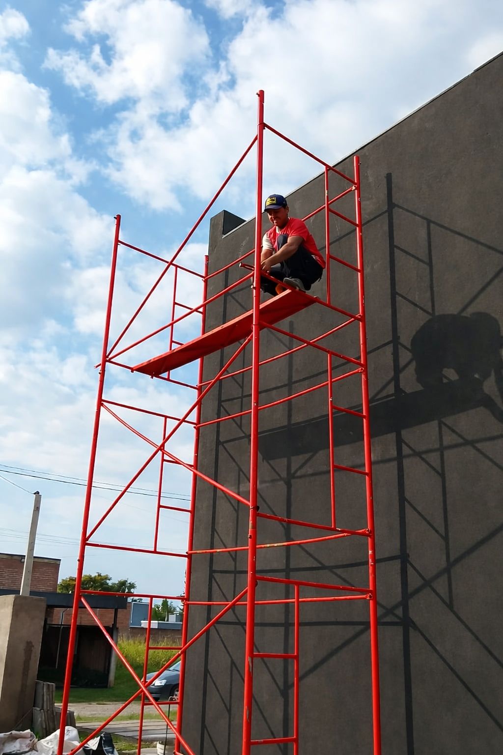 Trabajador en andamio rojo en exterior